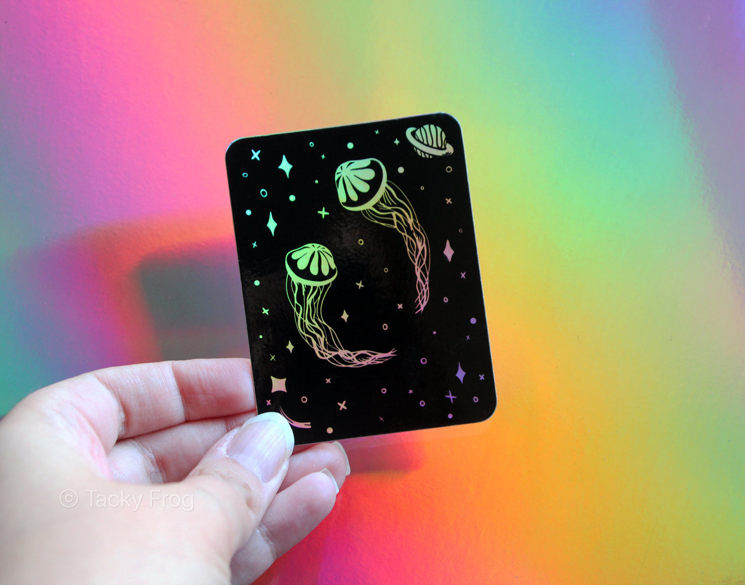 a holographic sticker depicting jellyfish floating in space