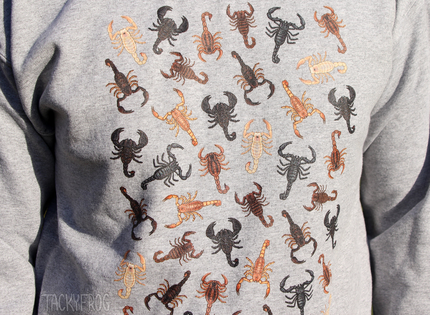 A closeup of the details on the scorpion sweatshirt. There are brown, black, tan, and cream-colored scorpions.