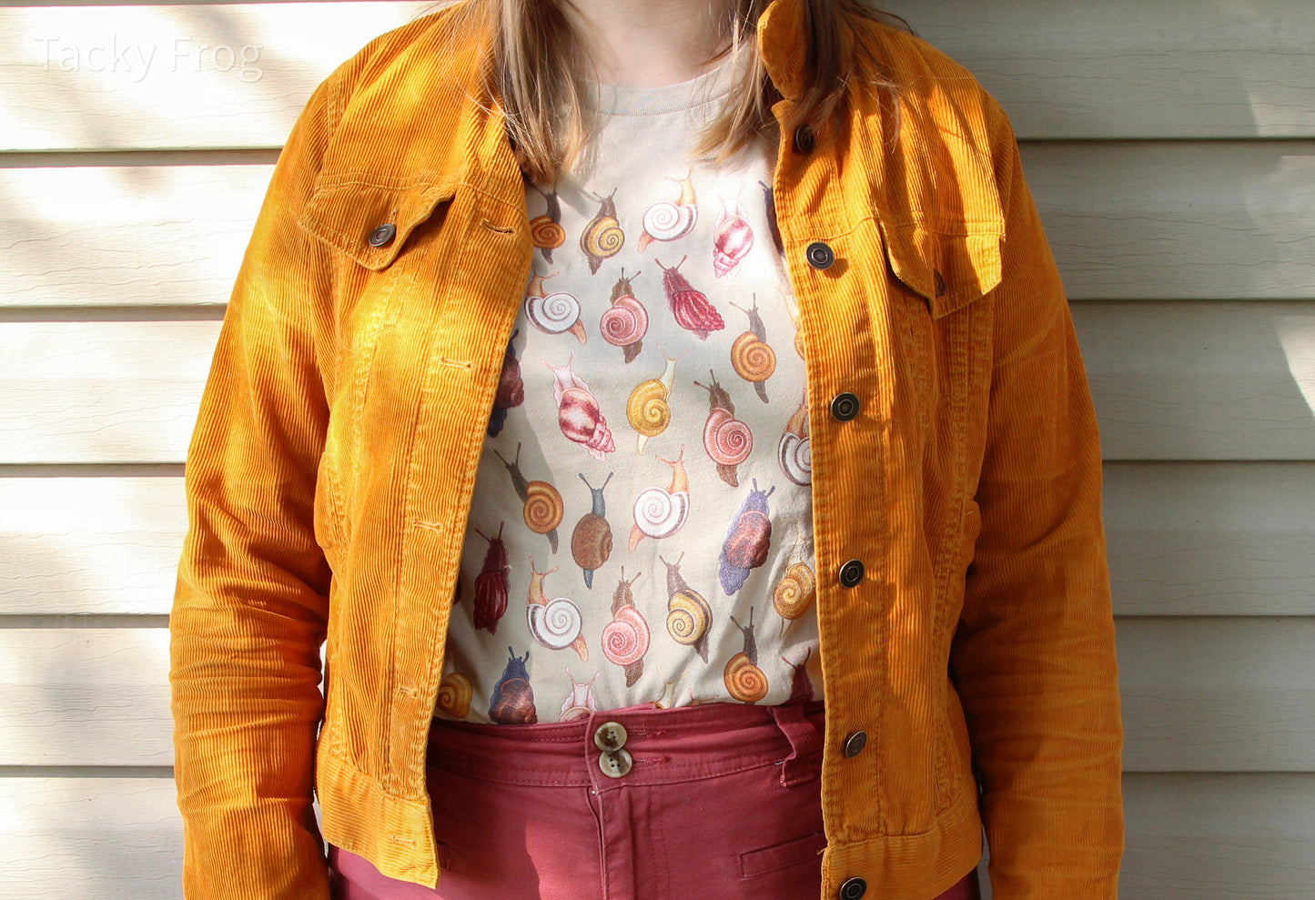 Another view of the snail t-shirt worn tucked-in under a yellow jacket.