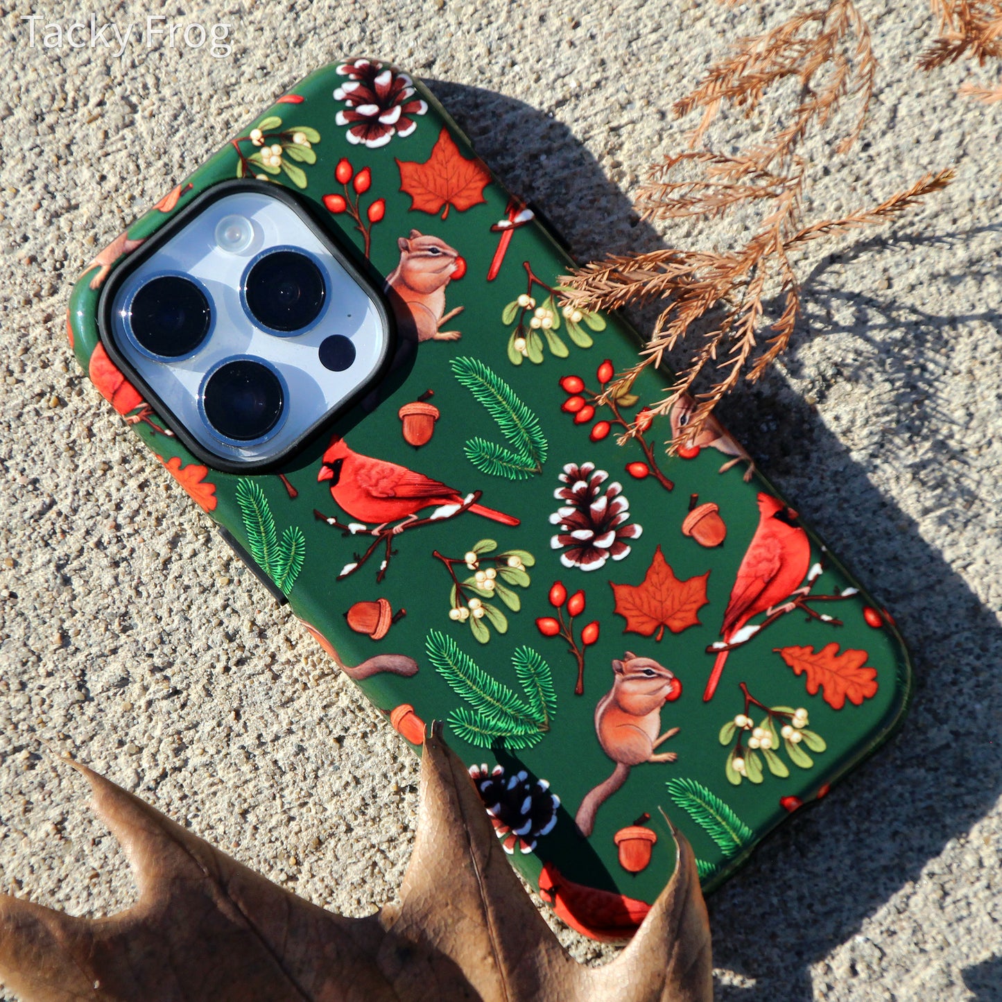 The winter nature hike-inspired phone case placed next to some dead leaves.