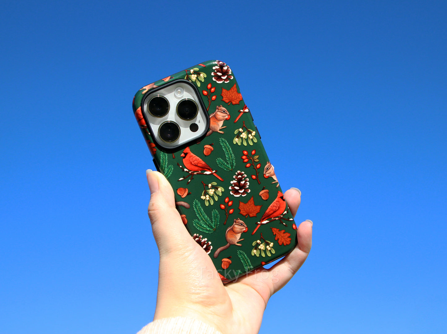 The winter nature hike-inspired phone case held up in the air.