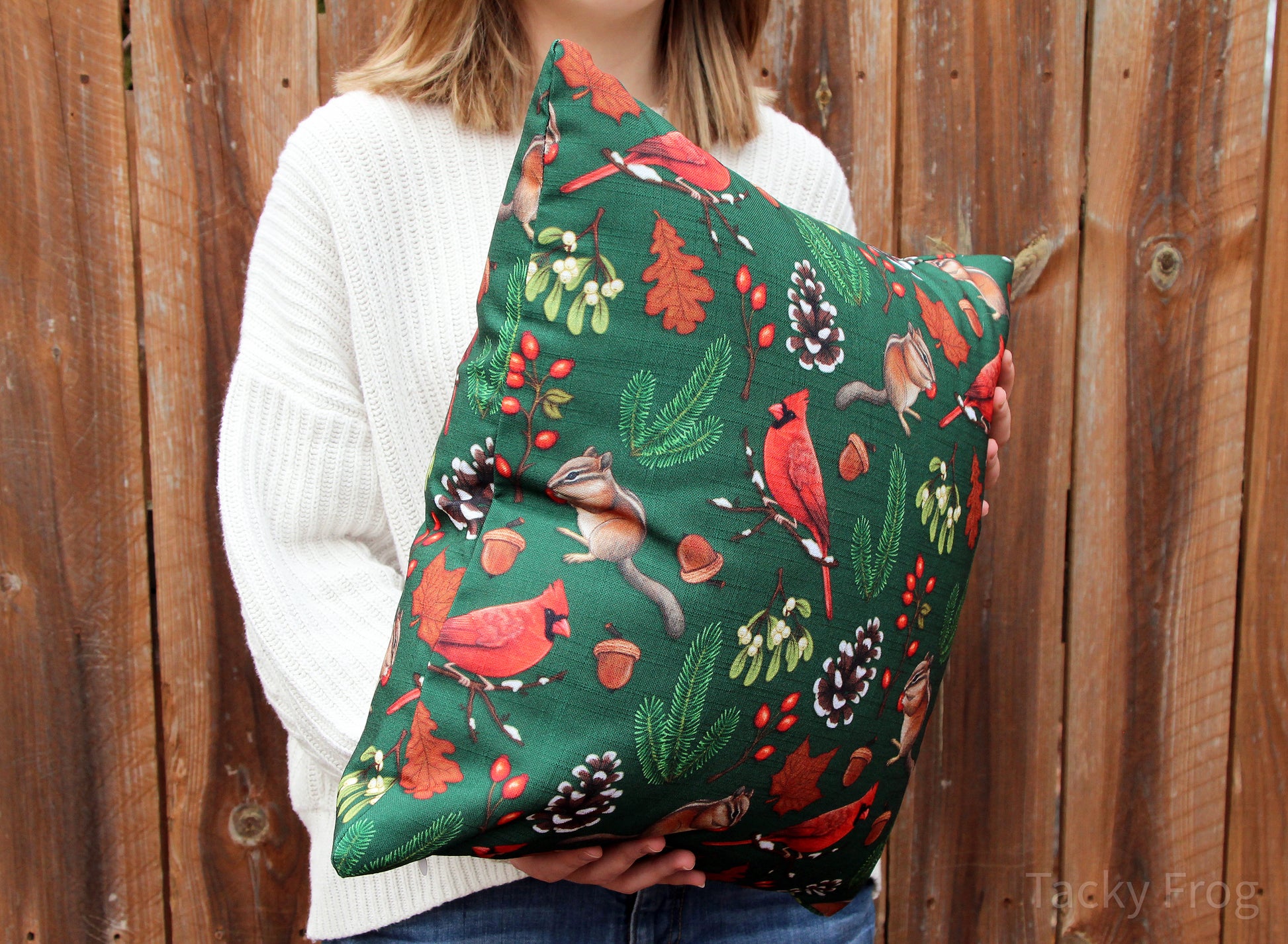 A young woman holding the winter foraging pillow, showing the seem on the side.