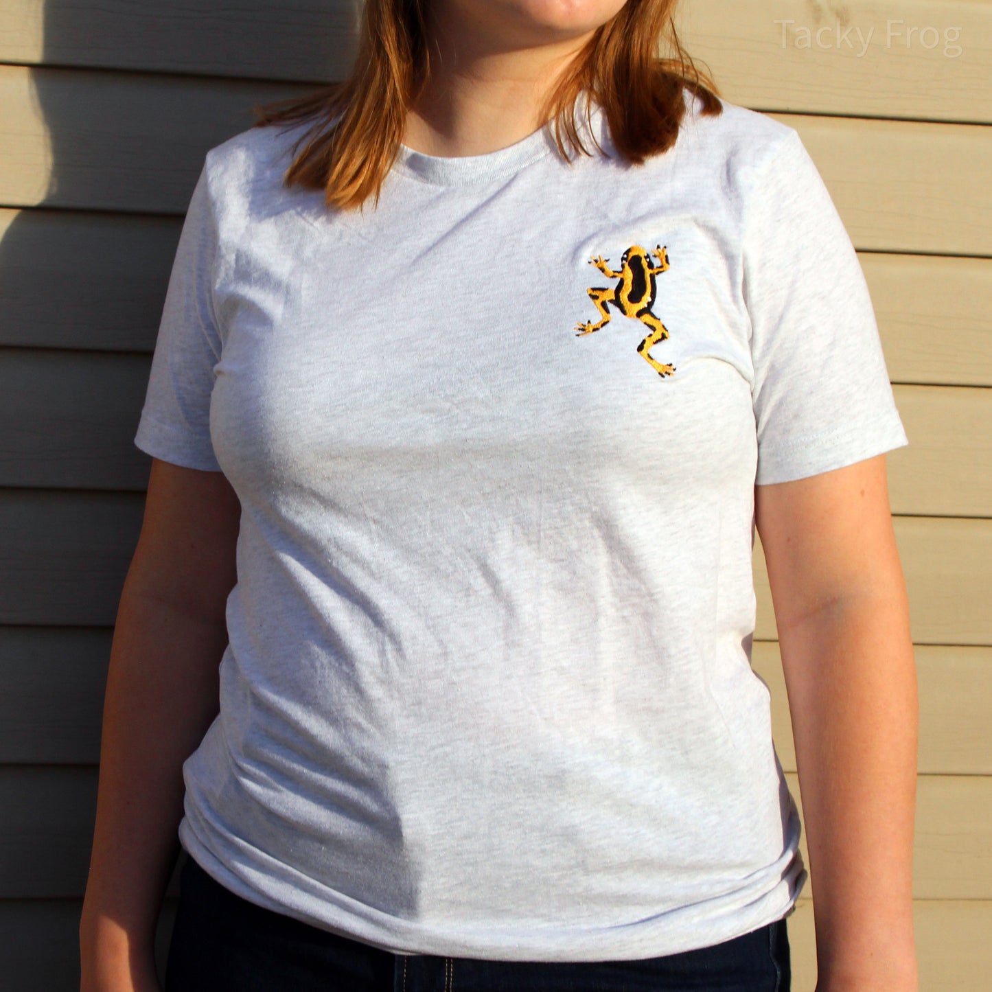 Another image of a woman wearing the yellow dart frog embroidered t-shirt.