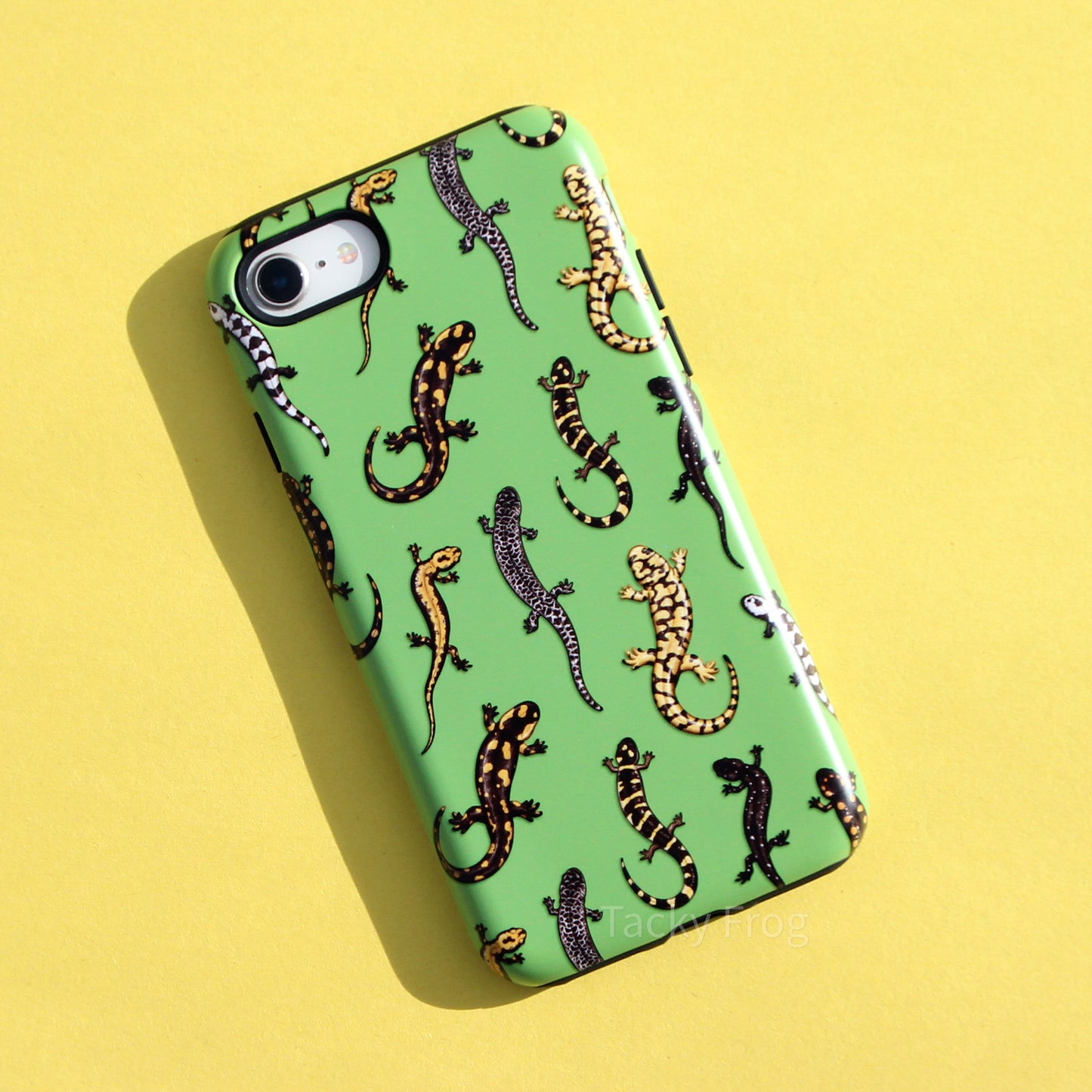 A green phone case featuring a pattern of salamanders. The salamanders are primarily yellow, dark brown, and/or white.