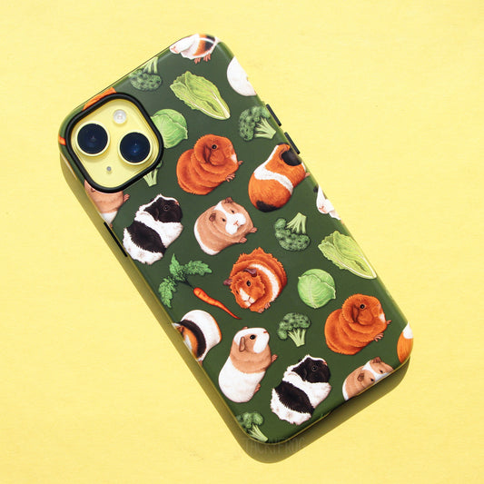 A green phone case featuring a pattern of orange, black, and white guinea pigs alongside vegetables.