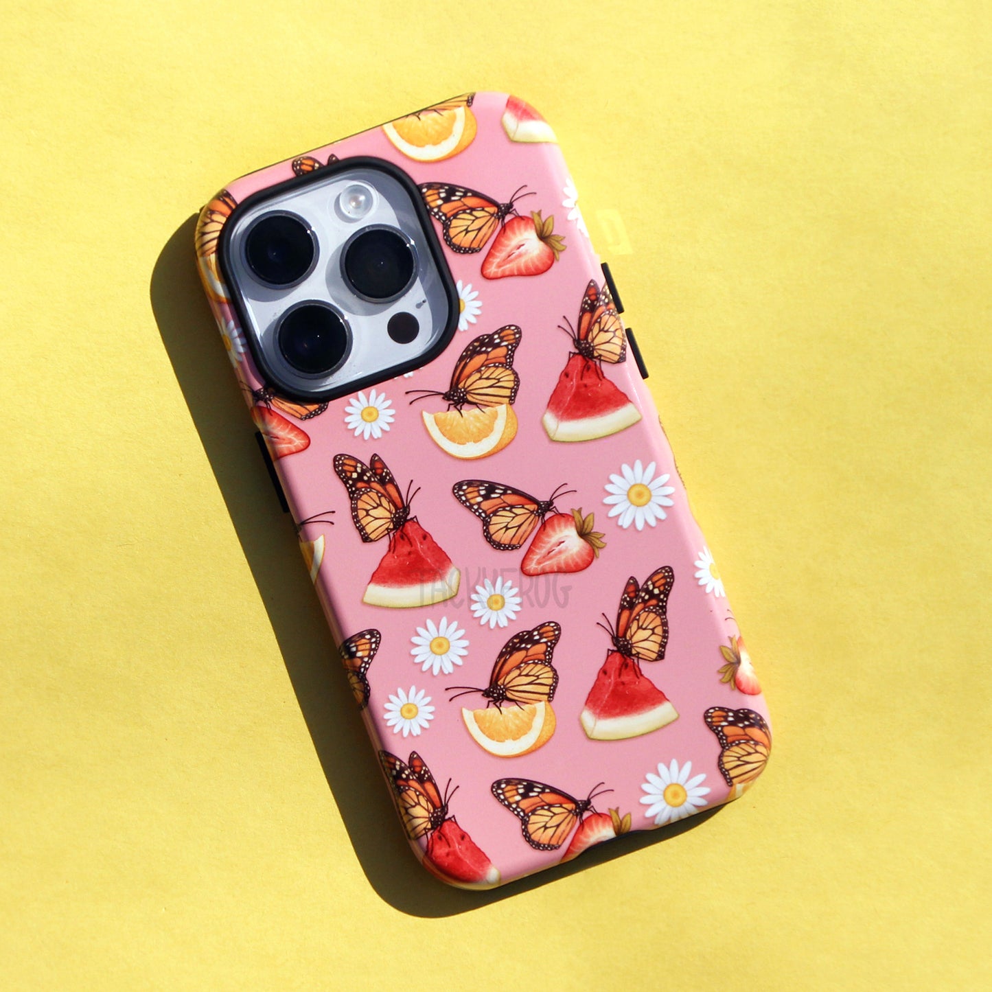 The hungry monarch butterflies with fruit slices phone case against a yellow background.