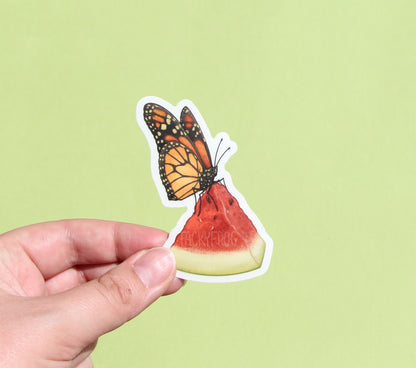 The monarch butterfly clear vinyl sticker with the white paper backing still on.