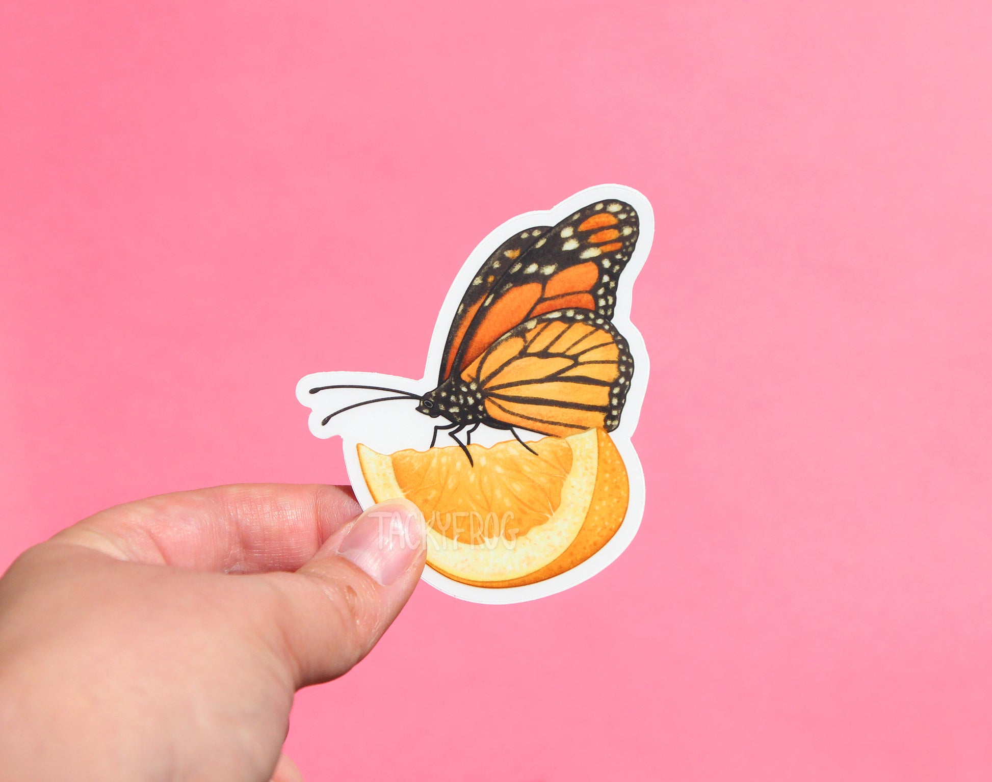 The monarch butterfly on a lemon slice sticker with the white paper backing still on