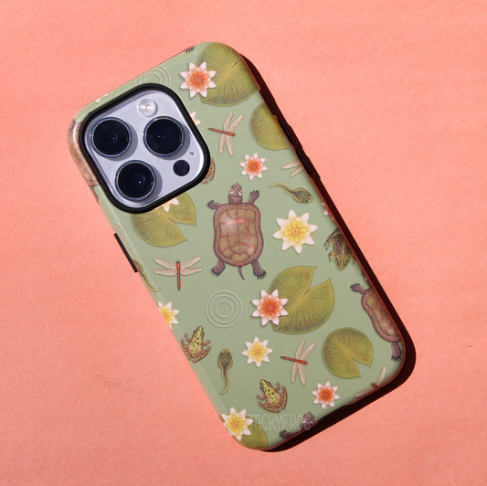 A light muted green phone case featuring a pattern of wildlife that can be found near ponds, including dragonflies, painted turtles, tadpoles, lily pads, and frogs.