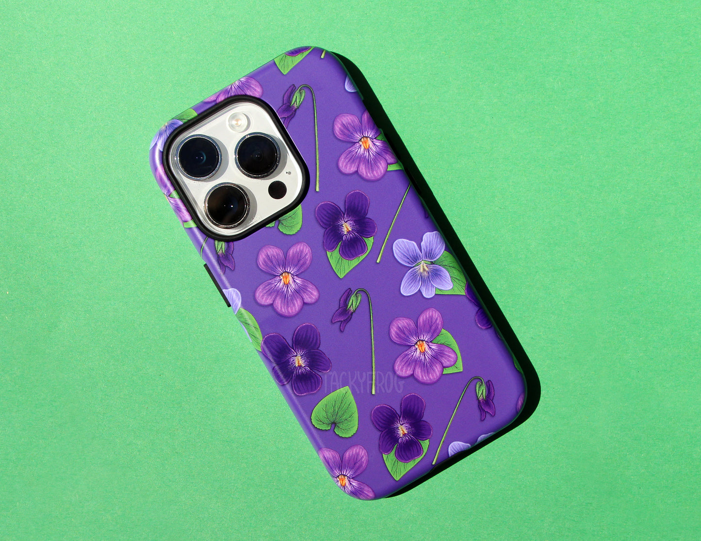 The violet-patterned phone case against a green background.