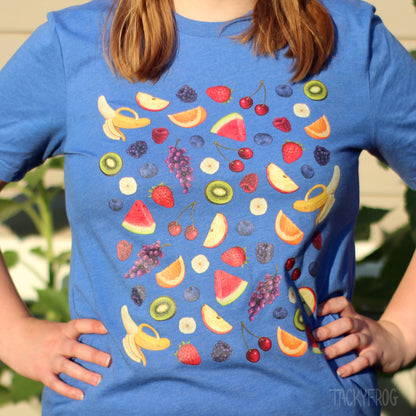 A woman wearing a blue t-shirt featuring a variety of fruits on it.