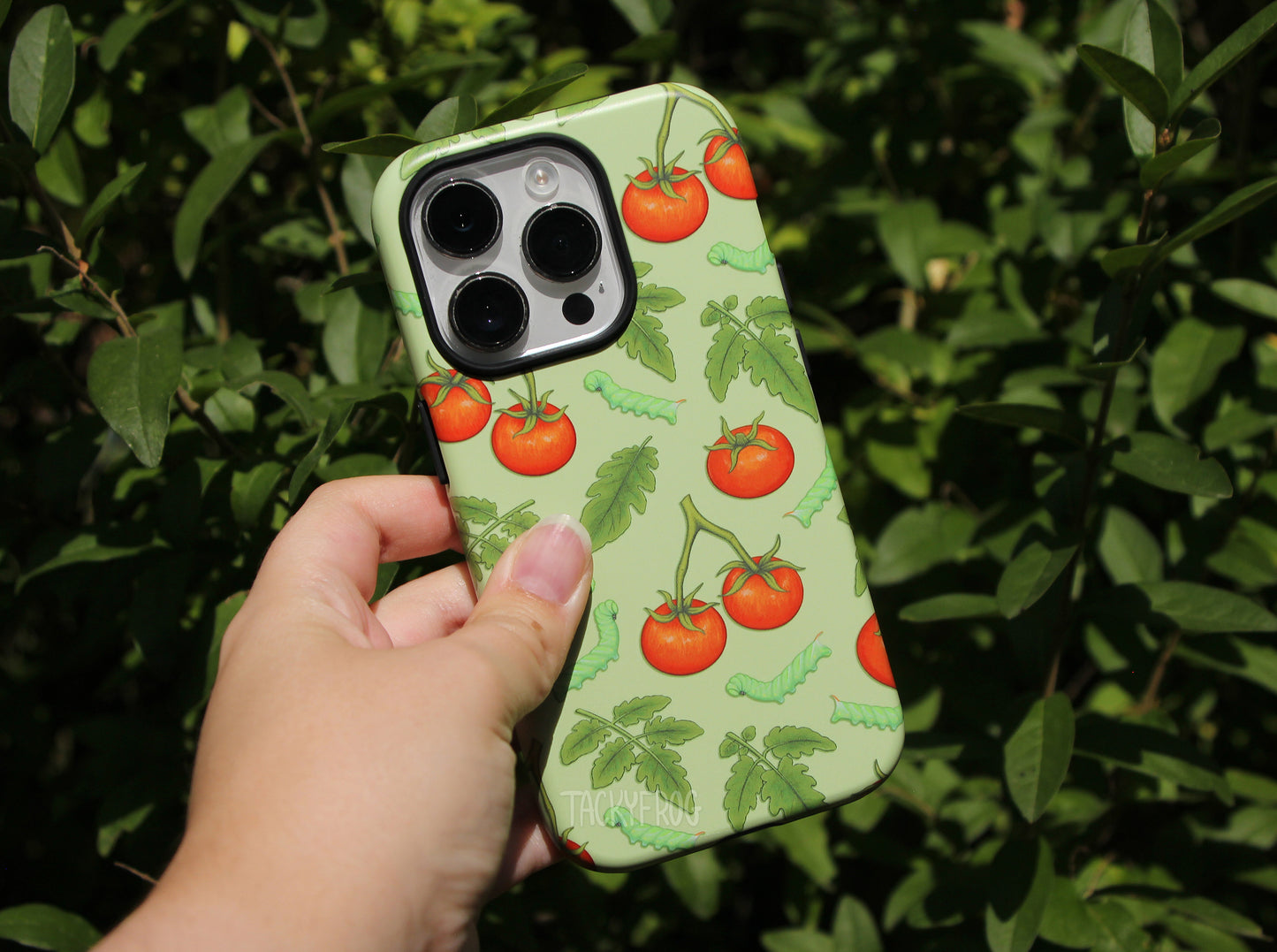 The tomato hornworm case held in front of a tree.