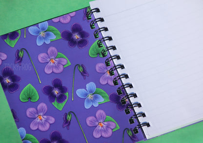 The inside covers of the notebook feature the same full-color pattern as the front covers. The notebook pages are ruled-lined.