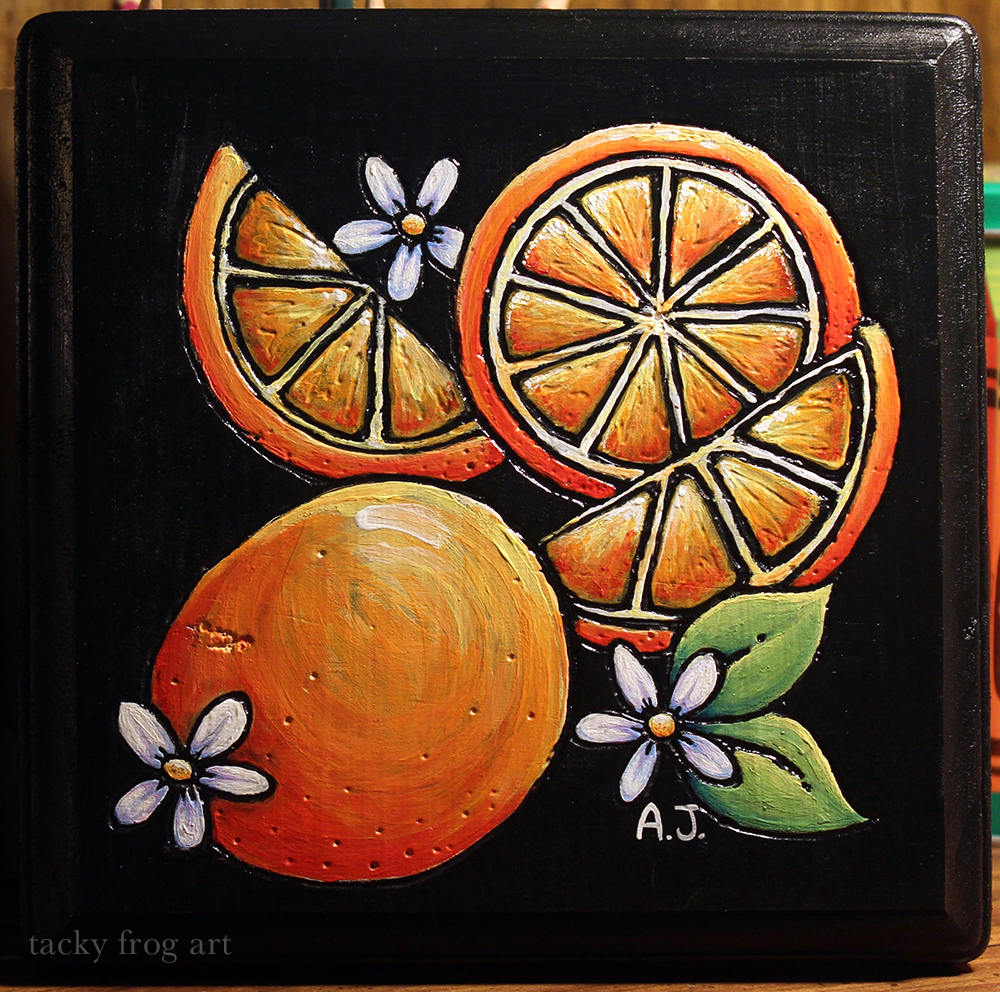 A piece of wood that has been wood-burned and painted to depict oranges and blossoms.