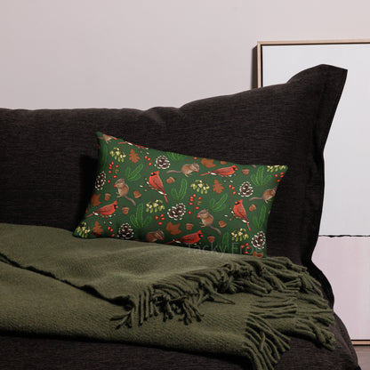 A mockup of a 20 x 12 inch winter foraging pillow on a dark grey bed.