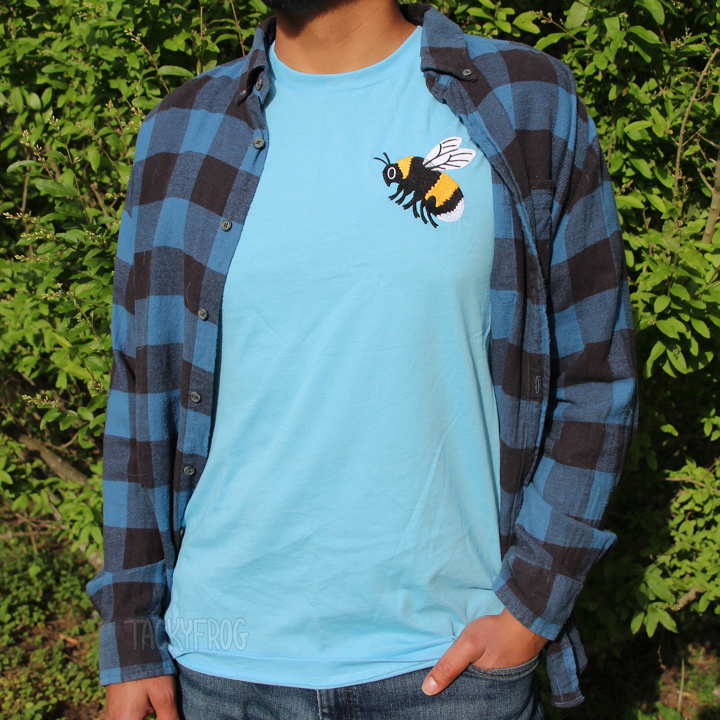 The bumble bee embroidered shirt, shown in the color "ocean blue" worn under a blue and black flannel. The flannel is not included.