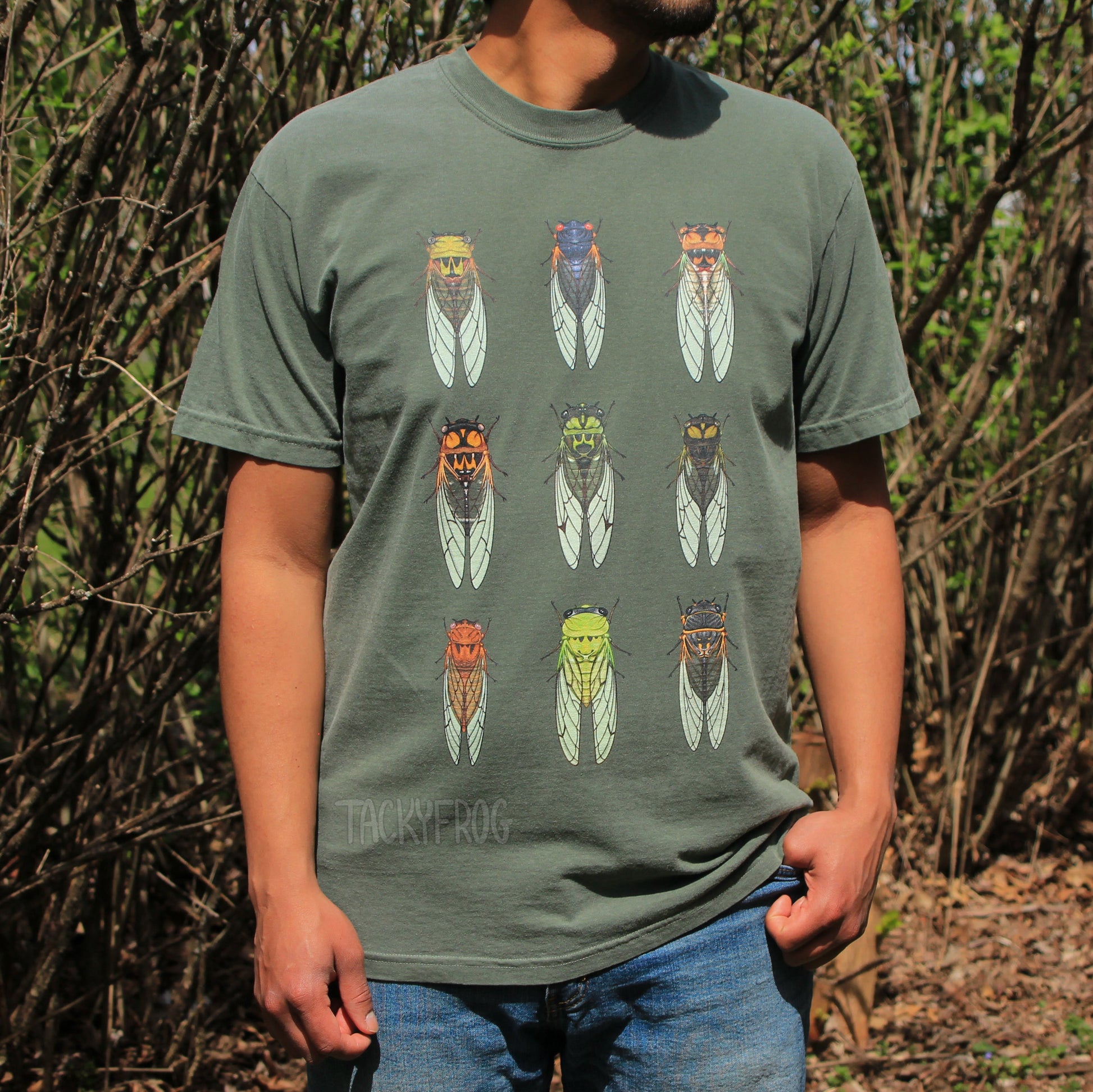 A man wearing a green t-shirt featuring illustrations of nine different cicadas.