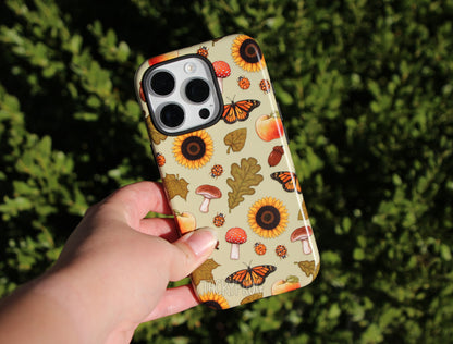 The early fall-inspired phone case against a leafy green background.