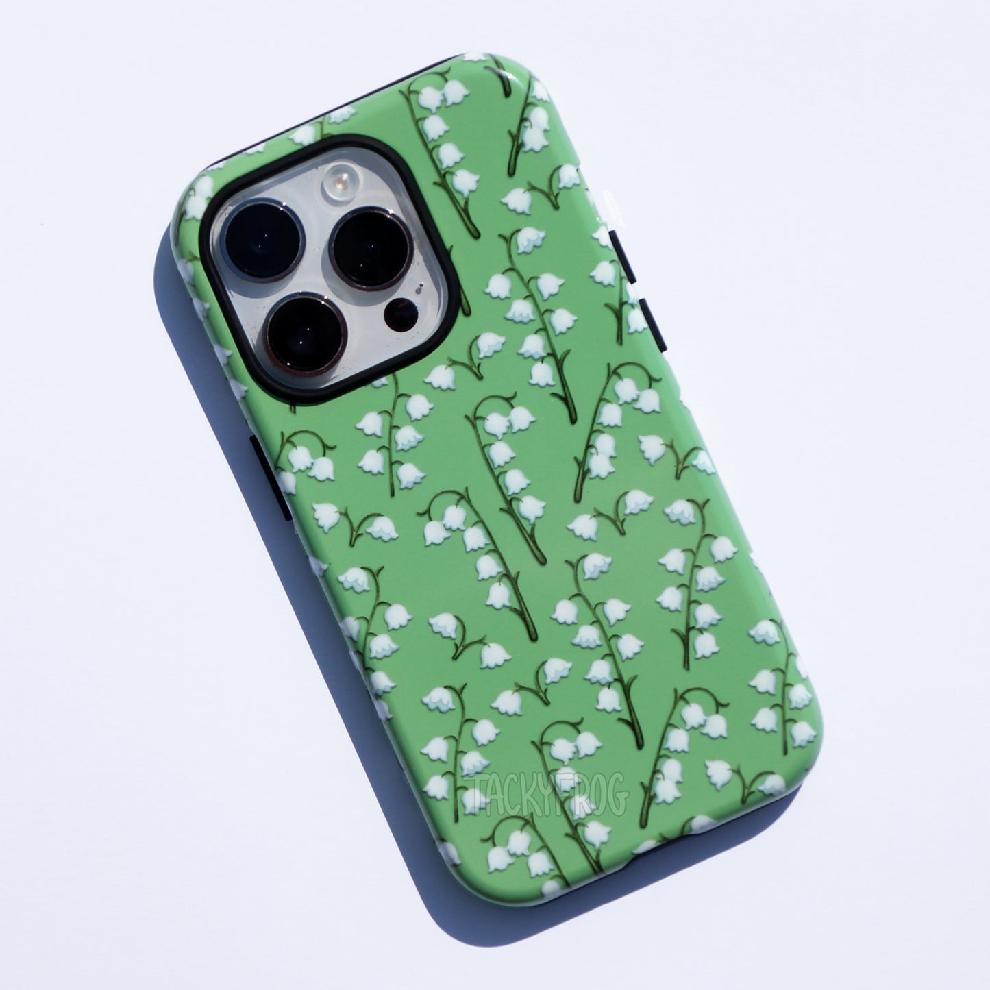 A green phone case featuring a pattern of lilies of the valley flowers.