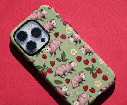Another close-up of the opossum phone case shown on a white-colored phone.