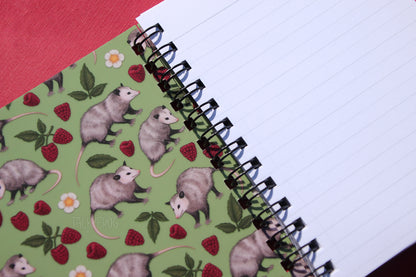 Both sides of both covers feature the full-color opossum pattern. The inner pages are ruled line.