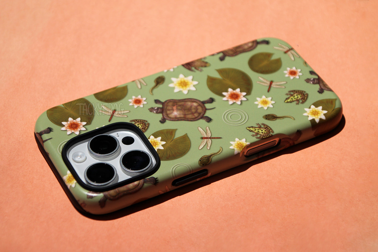 A close up of the details on the pond life phone case. The inner layer of the phone case is solid black, and it is visible around opening and buttons.