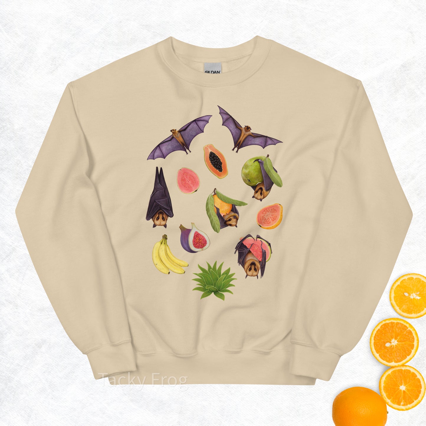 A mockup of the fruit bat sweatshirt in the color Sand. The mockup is surrounded by fruit.