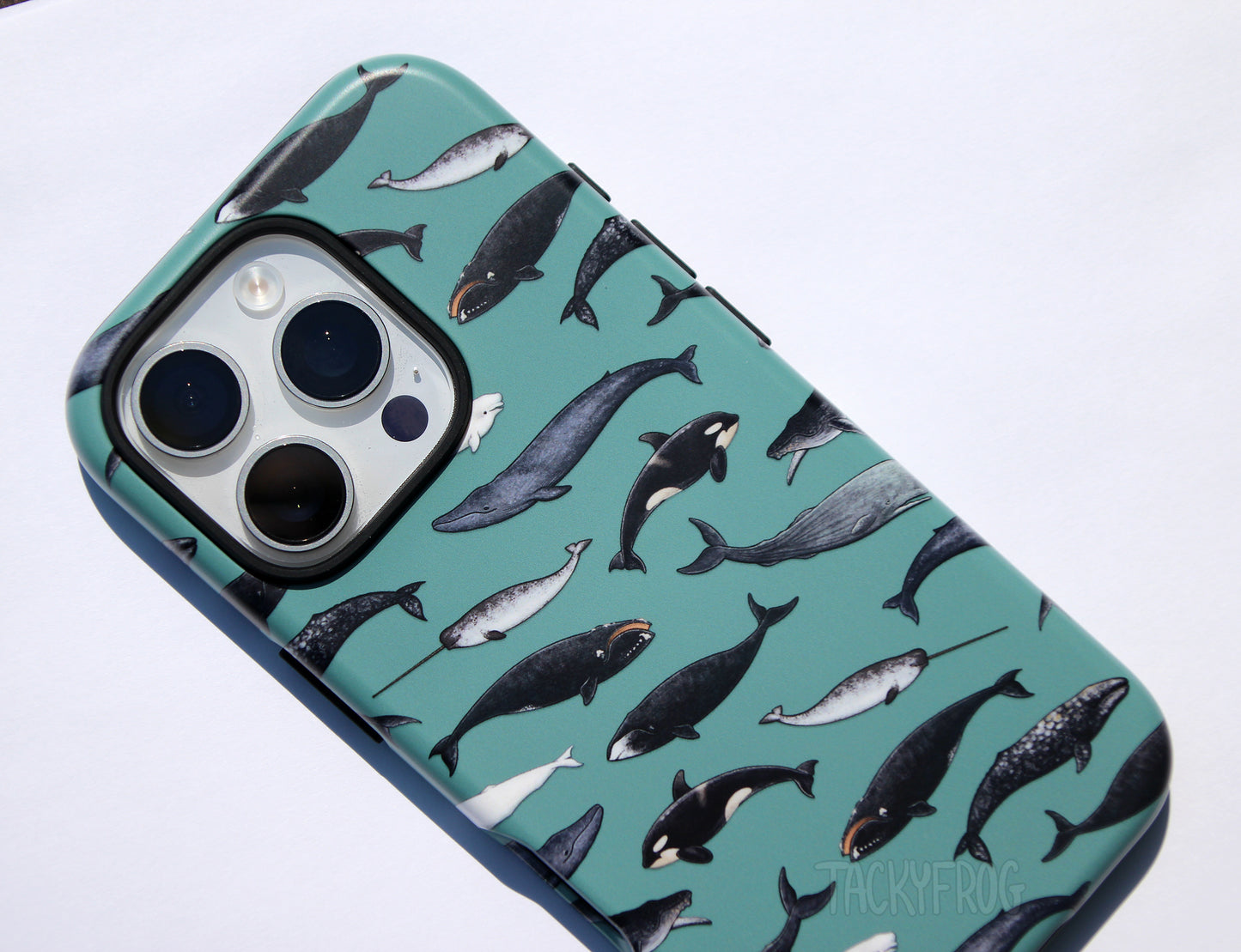 A close up of the whale phone case. There are nine species of whales depicted, including the humpback, orca, beluga, bowhead, and blue whale.