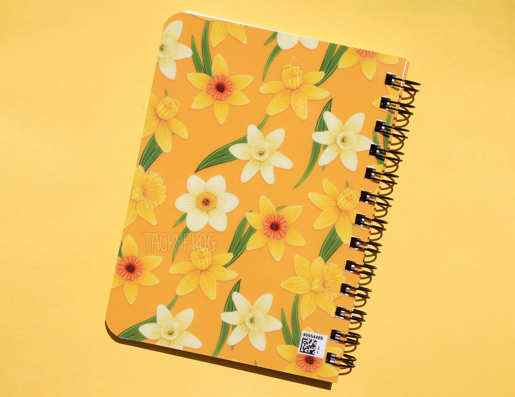 The back of the yellow daffodils mini notebook, which also features the colorful pattern. Please note there is a small QR code printed in the bottom right corner of the back cover.