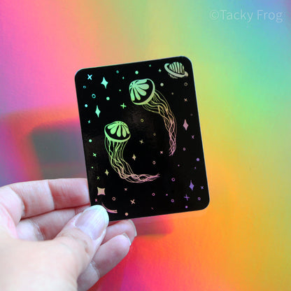 A space jellyfish holographic vinyl sticker. It appears rainbow when it catches the light in certain ways.