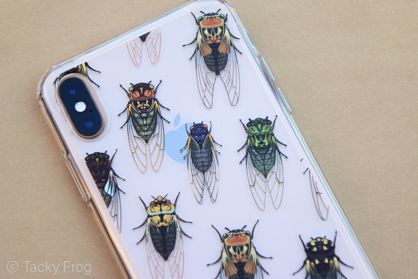 A clear phone case, shown on an iPhone, with a cicada pattern on it.