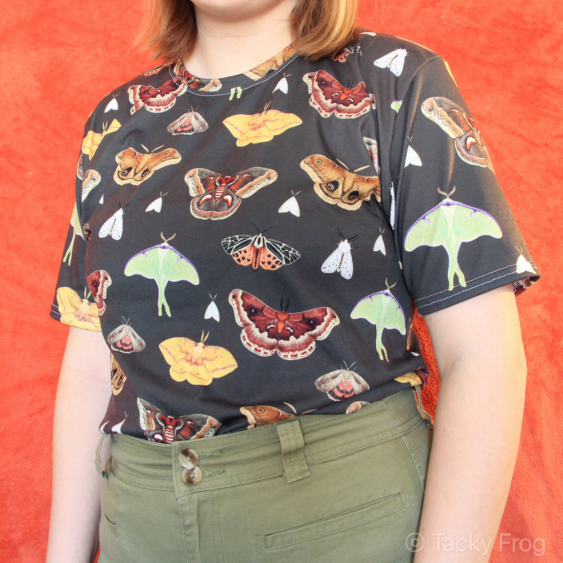 A brown t-shirt with a moth pattern on it.