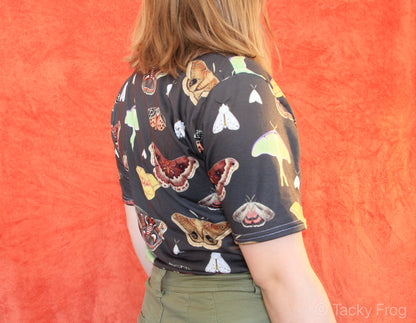 A brown t-shirt with a moth pattern on it.