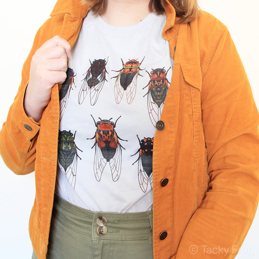 A t-shirt with cicadas on it, worn under an orange jacket.