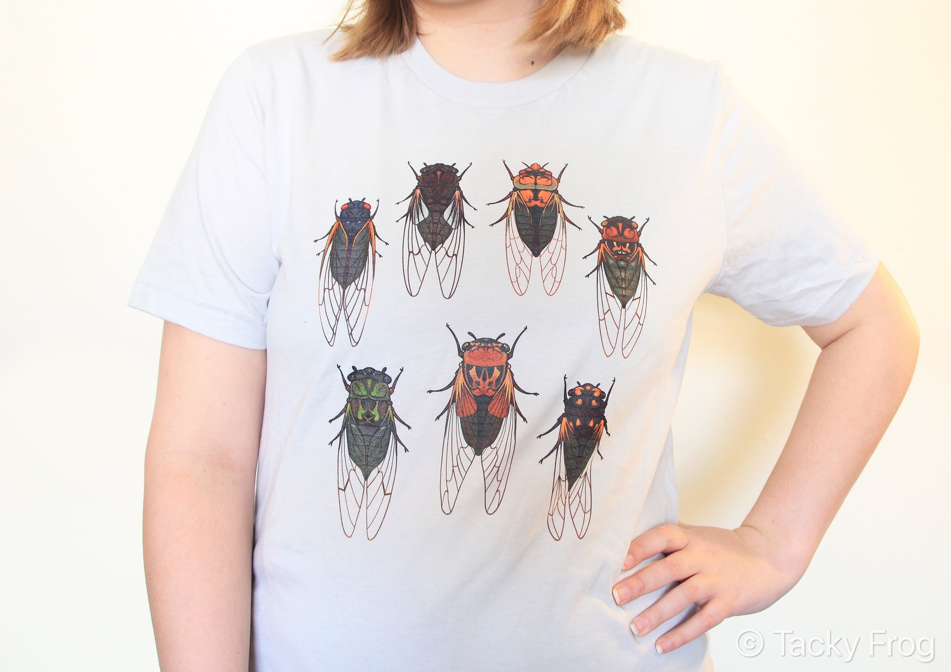 A silver-colored t-shirt with cicadas on it.