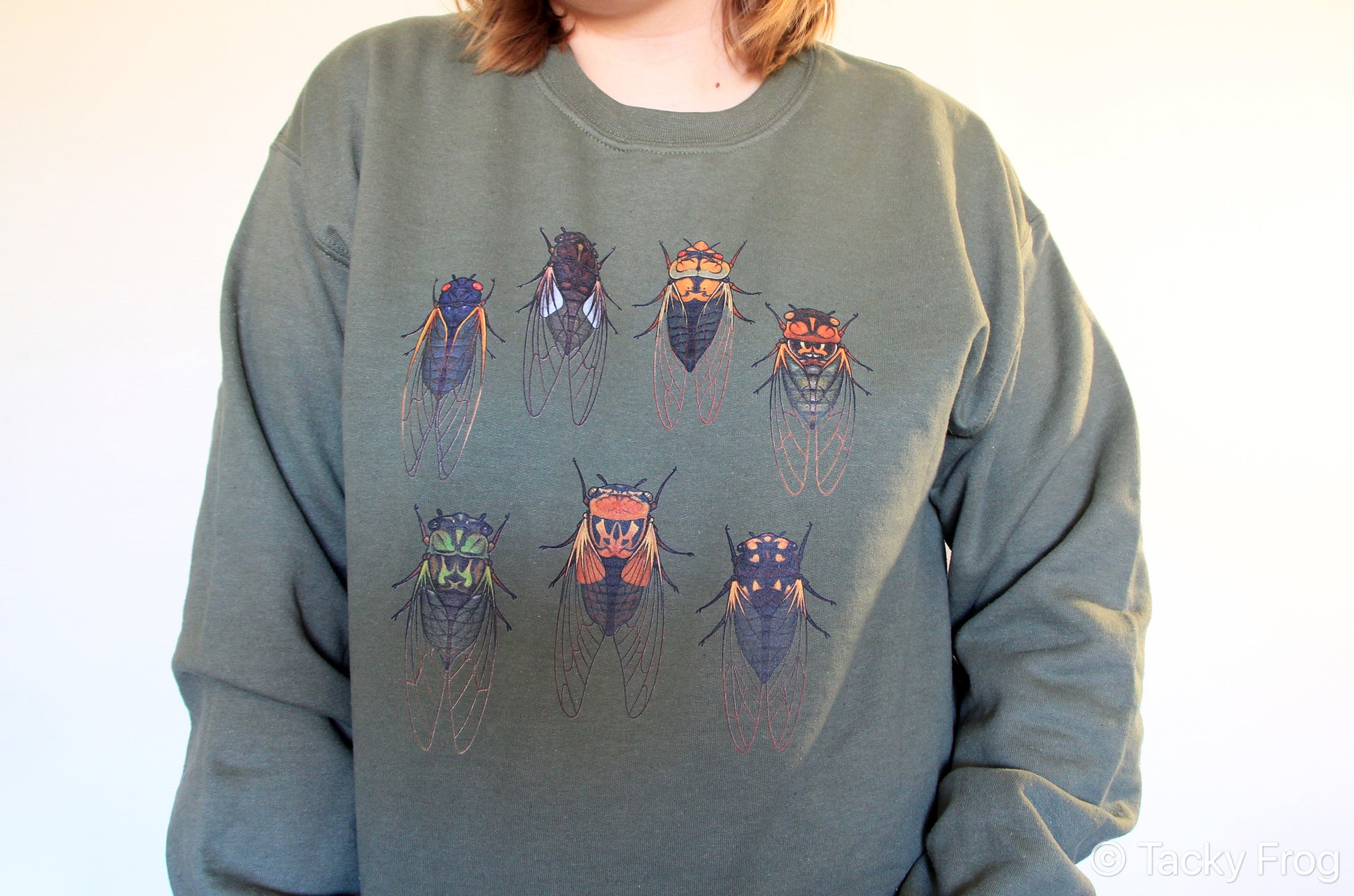 A woman wearing a green sweatshirt with cicadas on it.