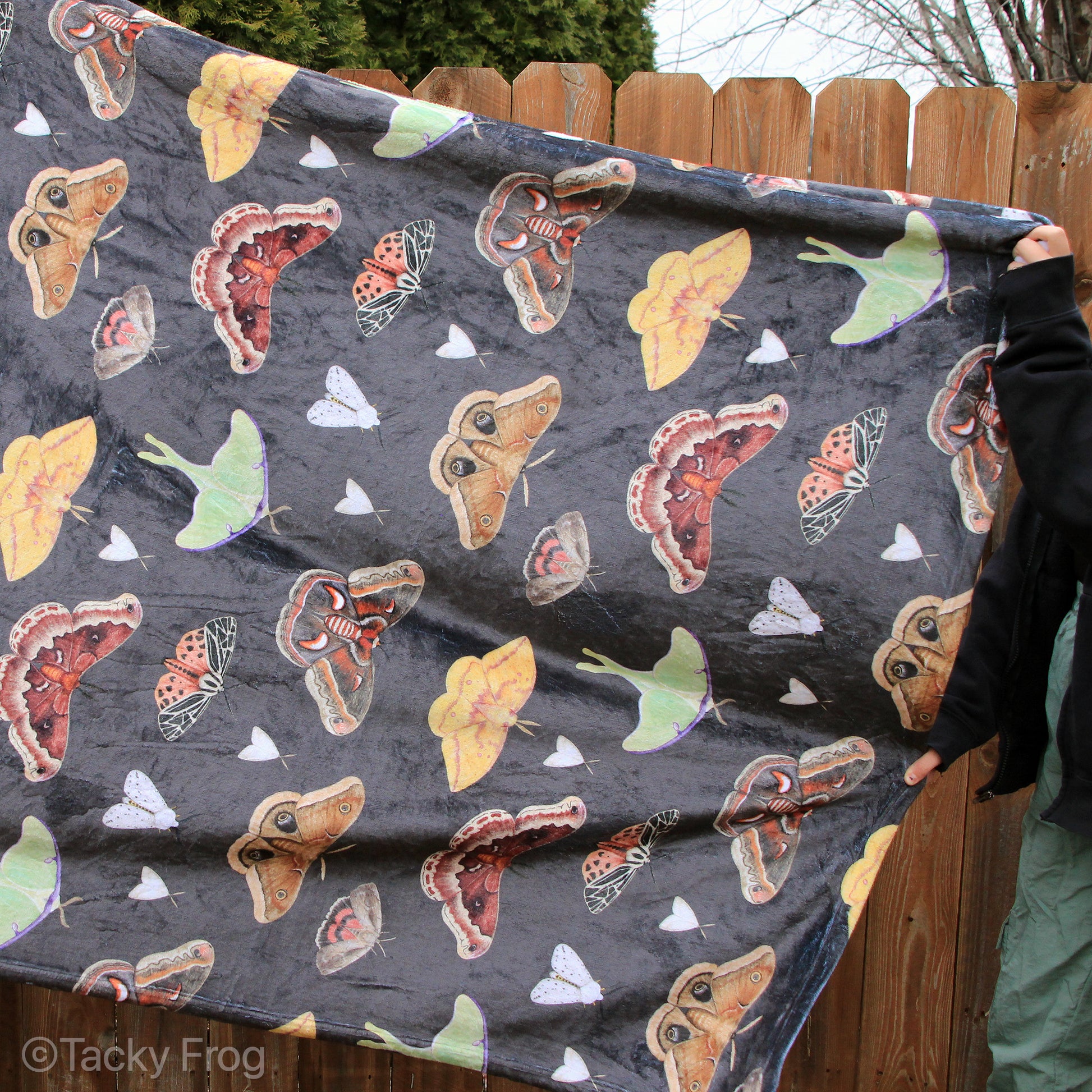 A brown blanket with a moth pattern on it.