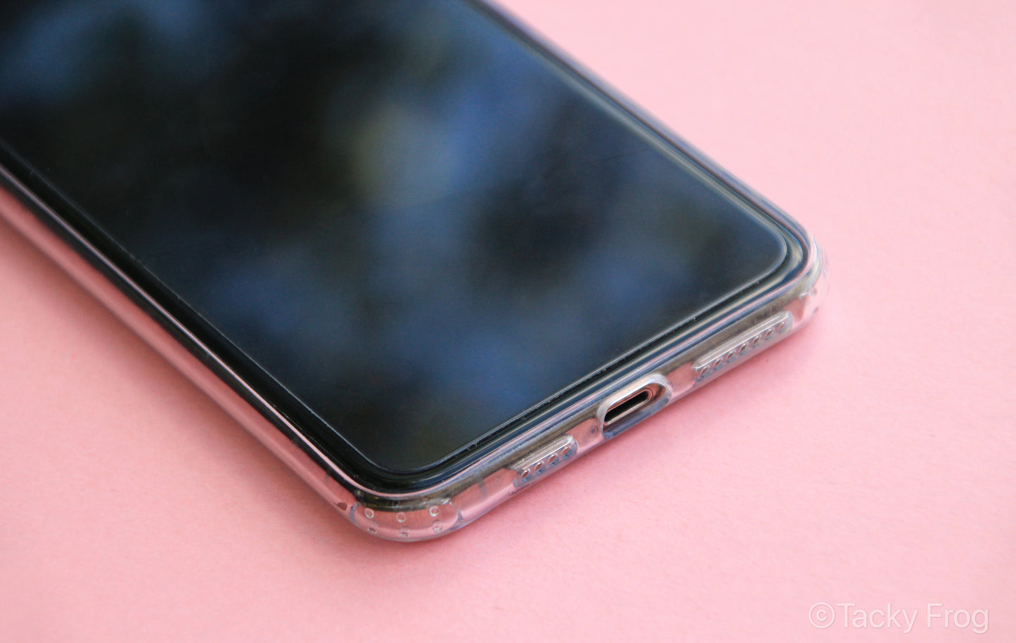 A view of the phone's charging port with the clear phone case on, shown screen-side up.