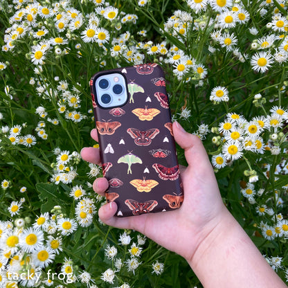 A brown phone case with a moth pattern on it.