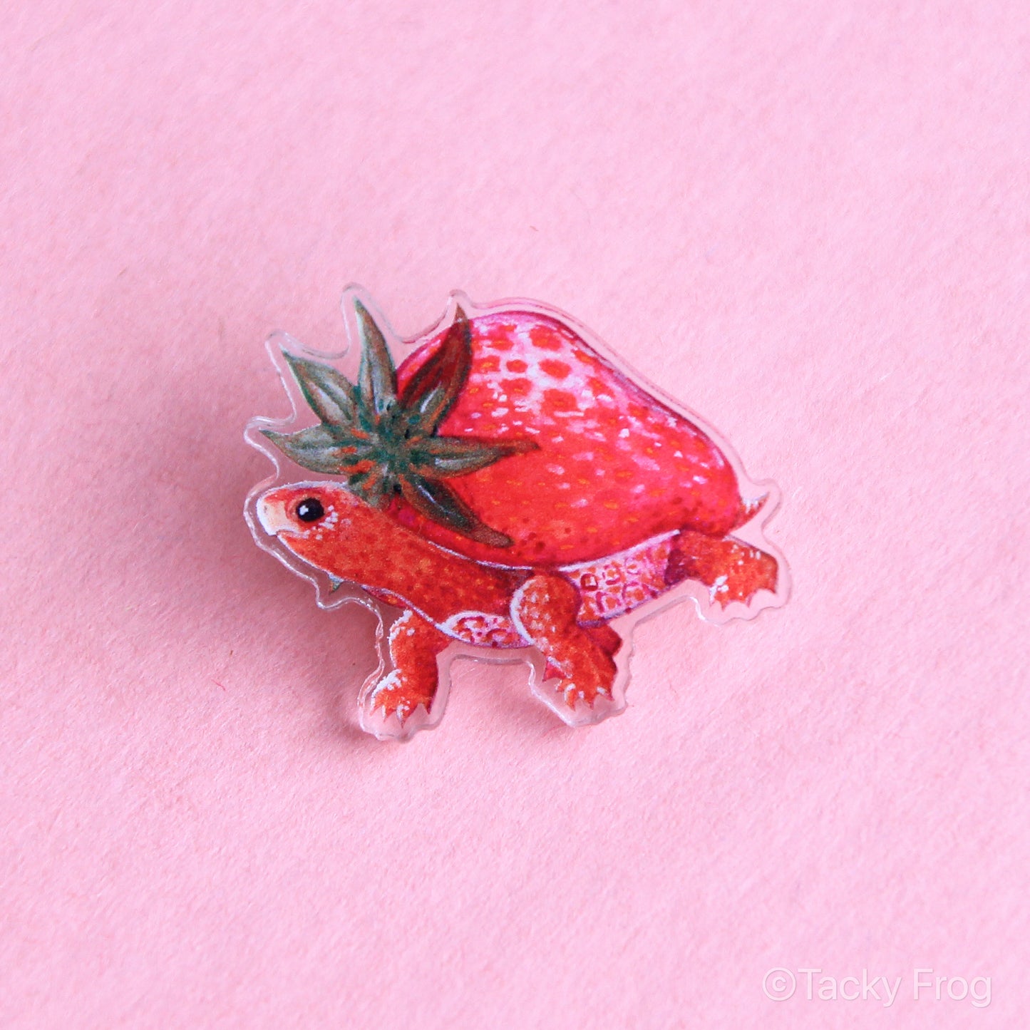 An acrylic pin of a strawberry turtle.