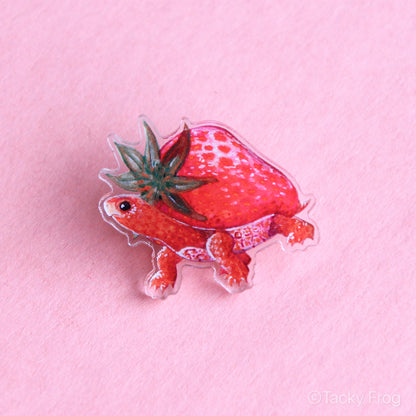 An acrylic pin of a strawberry turtle.