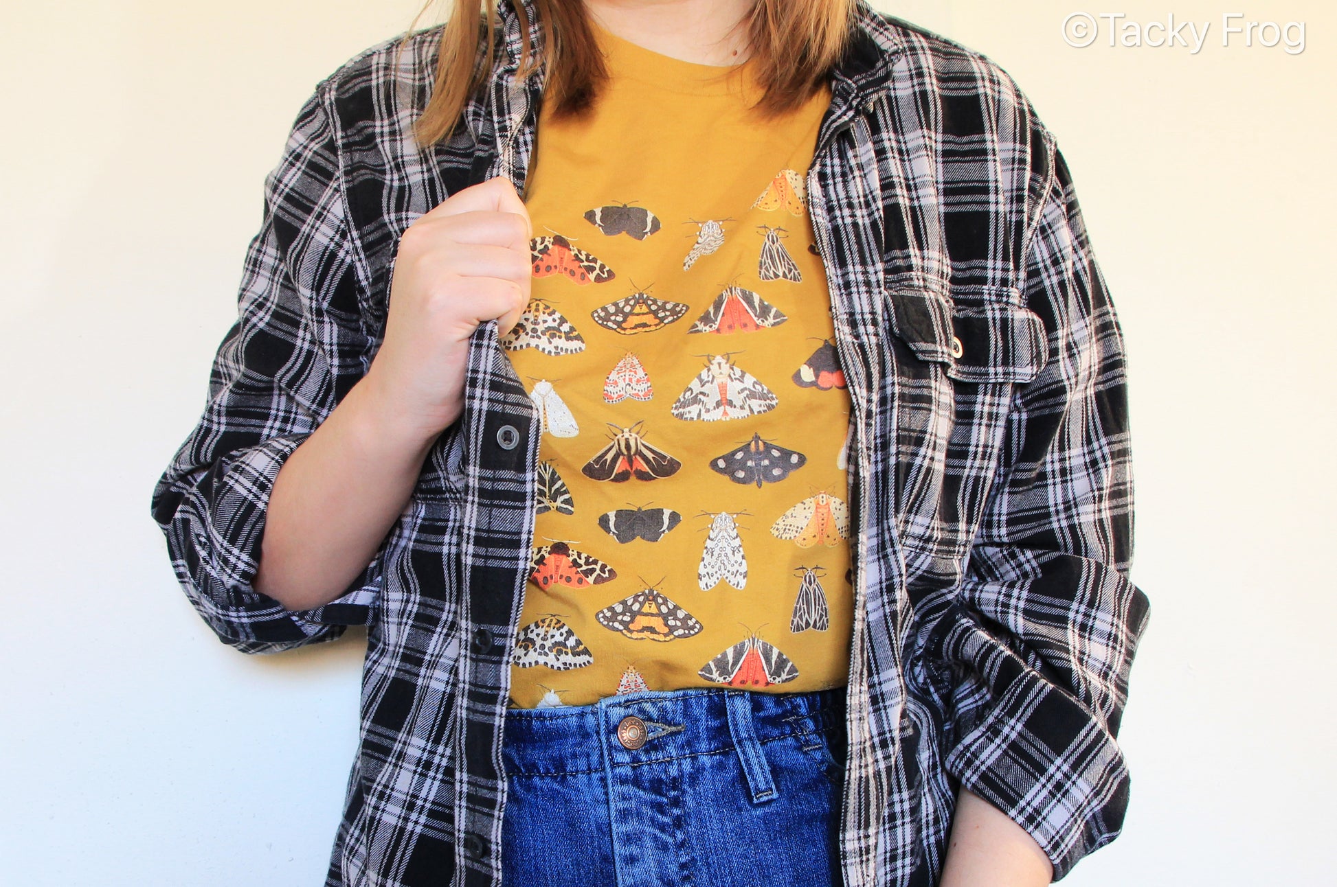 The mustard yellow moth t-shirt worth under a black and white flannel.