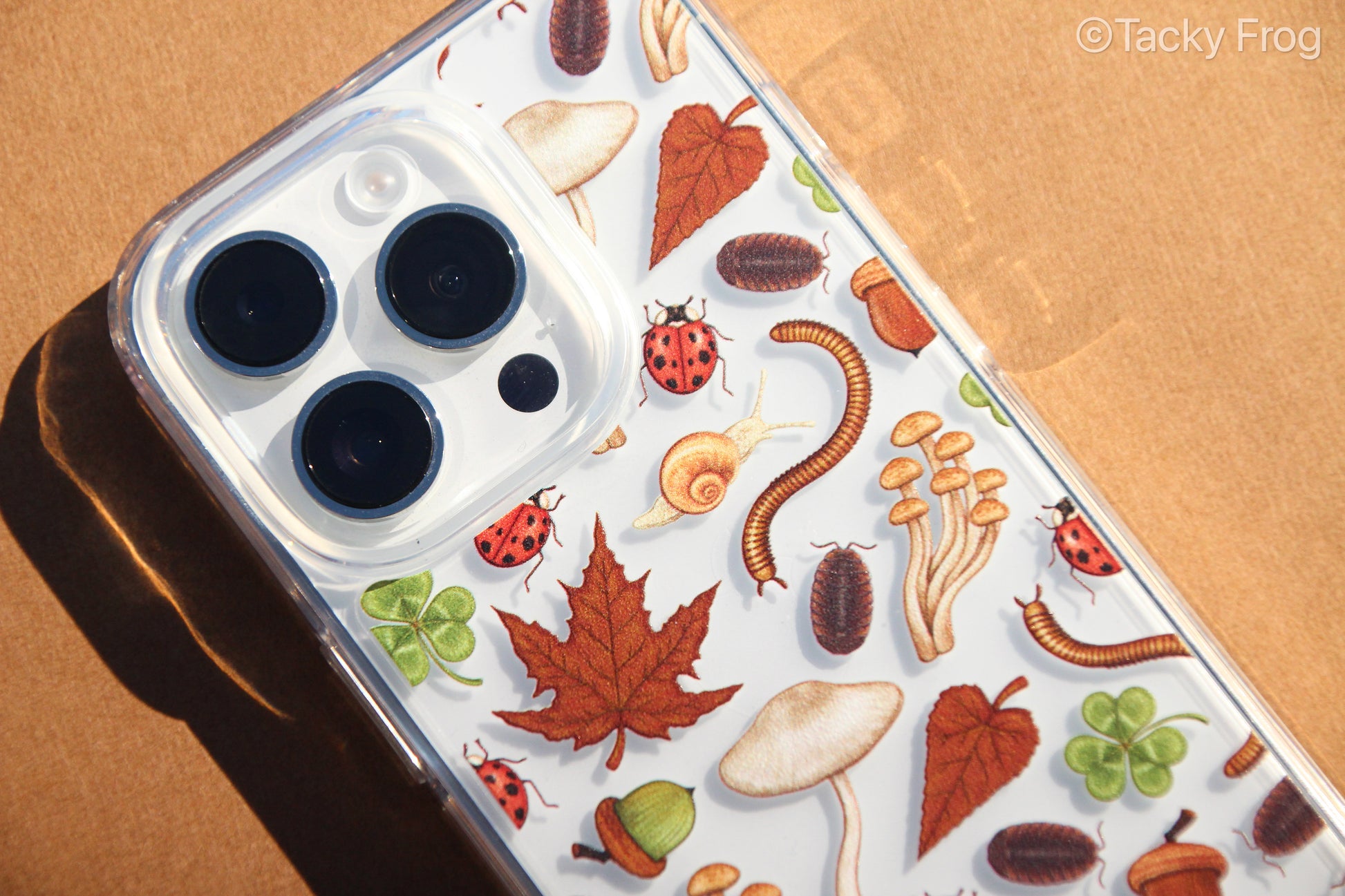 A close up of the pattern on the nature-inspired phone case. The bugs featured on the phone case are ladybugs, millipedes, pill bugs, and snails. 