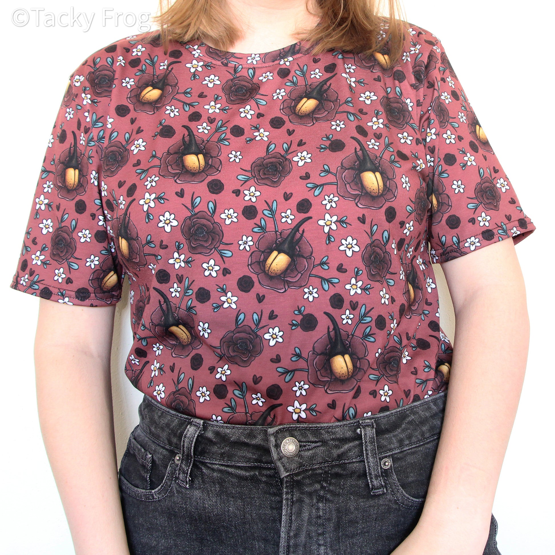 A woman wearing the floral Hercules beetle all-over print t-shirt tucked in.