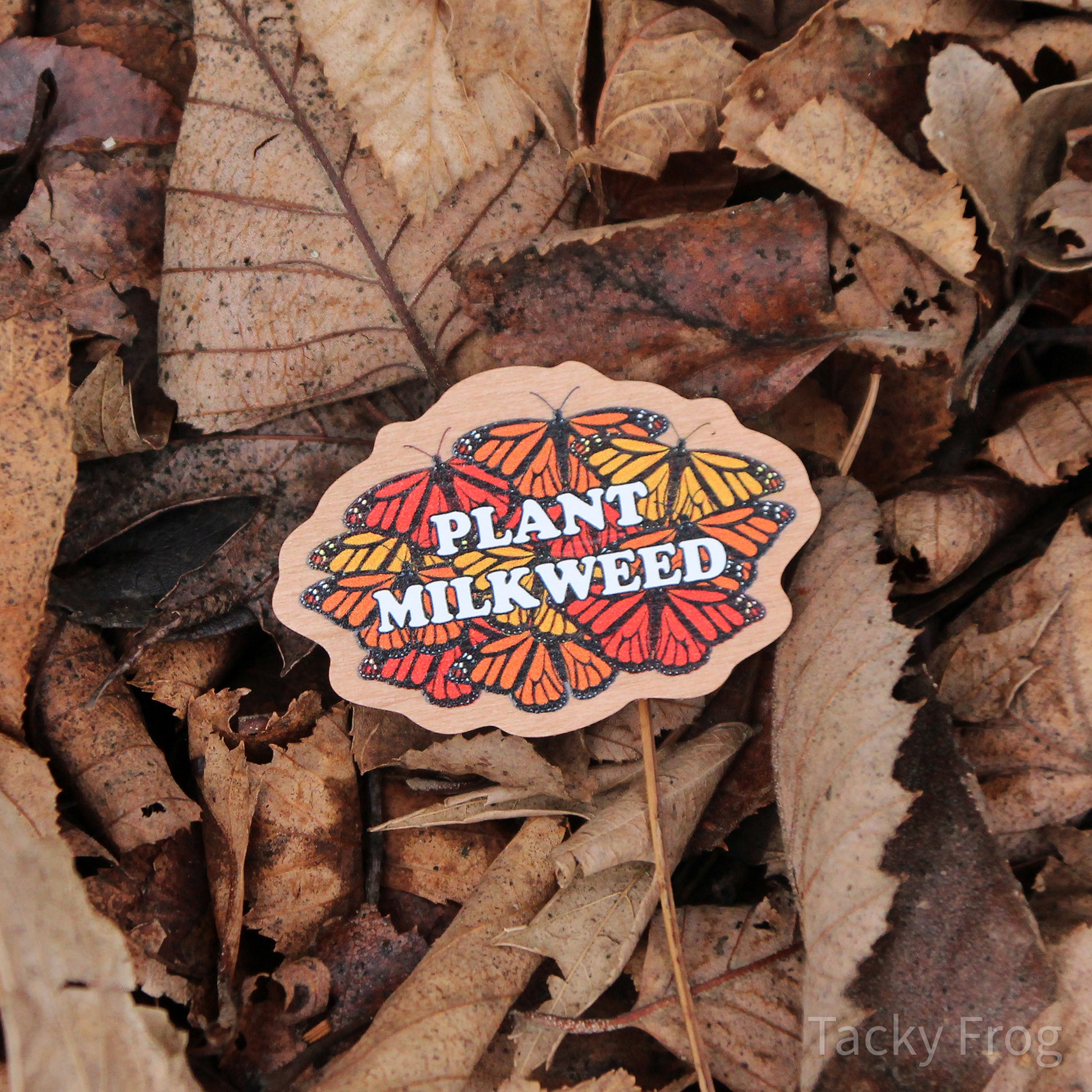 The plant milkweed pin placed in a pile of dead leaves.