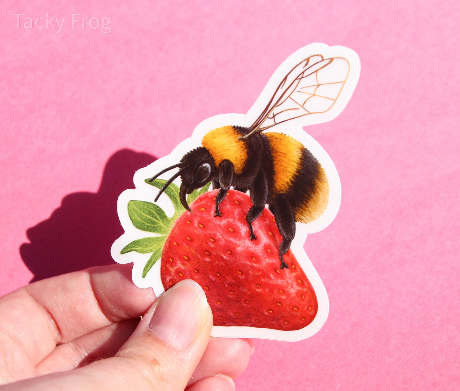 The bumblebee on a strawberry sticker with the white paper backing still on.