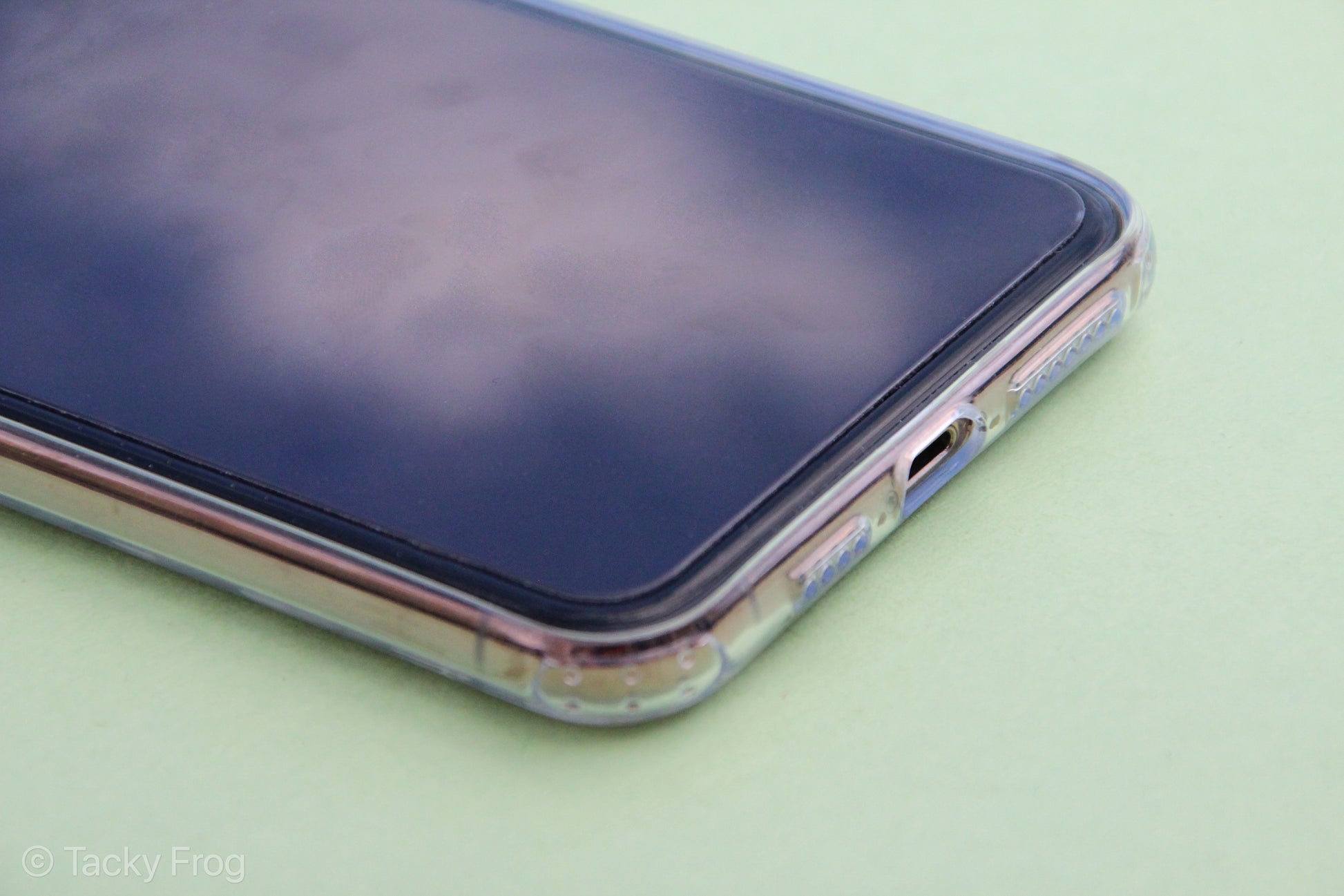 A clear phone case shown on the lower half of an iPhone, screen-side up.