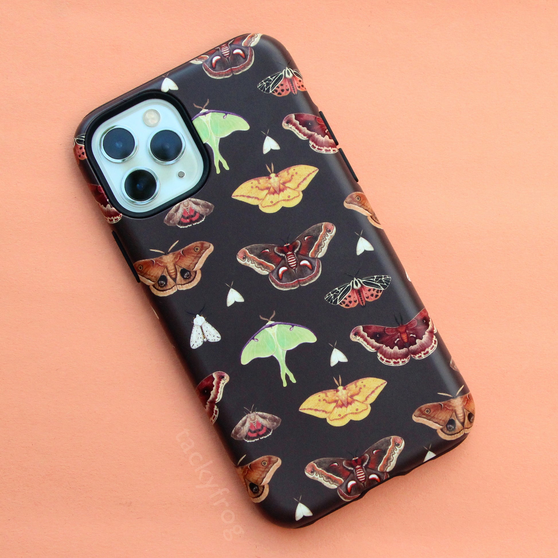 A brown phone case with a moth pattern on it.