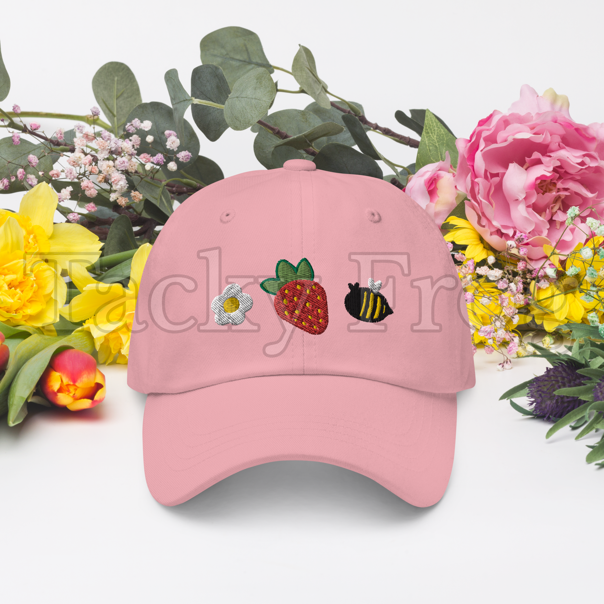 A mockup of the pink strawberries and bees embroidered hat. There is a watermark over the image.