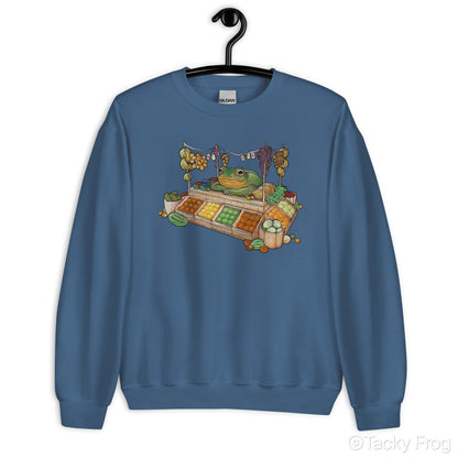 A mockup of the fruit vendor frog design on an indigo blue sweatshirt.